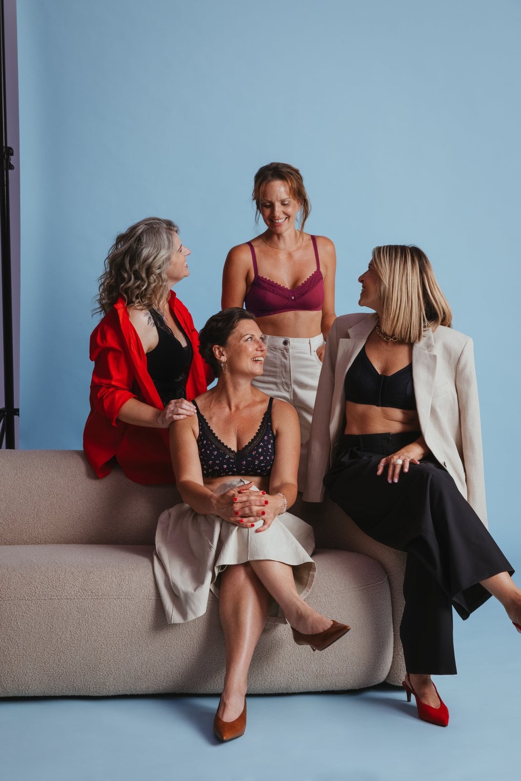 Les quatre femmes rient ensemble sur le canapé du studio pendant le shooting.