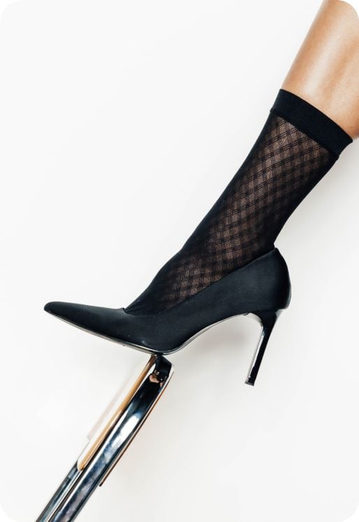 Paire de chaussettes noires semi-opaques à motif quadrillé.